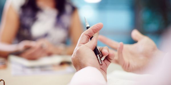 A close-up of a person's hand holding a pen
