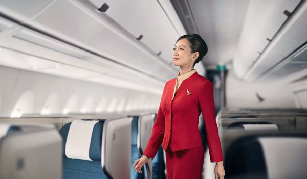 穿紅色制服的空服員站在飛機內。