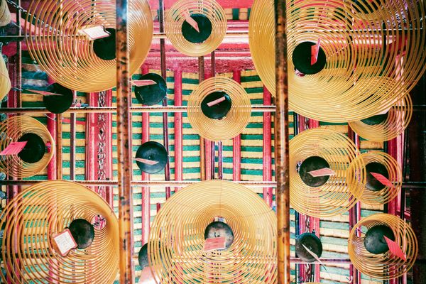 An overhead view of circular incense coils hanging from the ceiling.