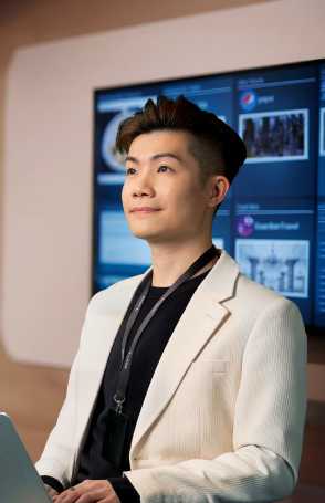 A male employee in a modern conference room with a laptop