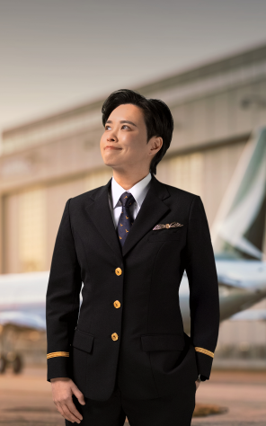 A female second officer in uniform stands at the front gate with the cathay logo behind her.