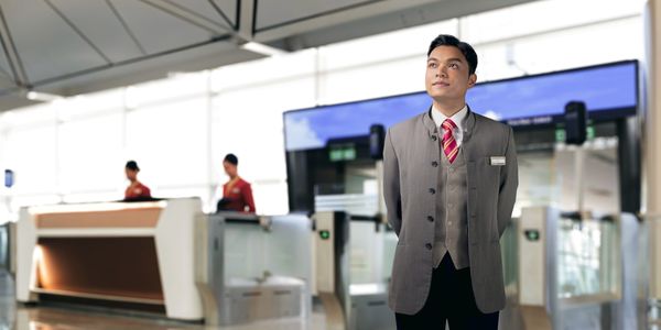 A Customer Services Officer standing in front of the boarding gate.