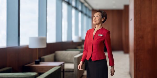 A Lounge Ambassador in uniform standing in the Cathay lounge hallway.